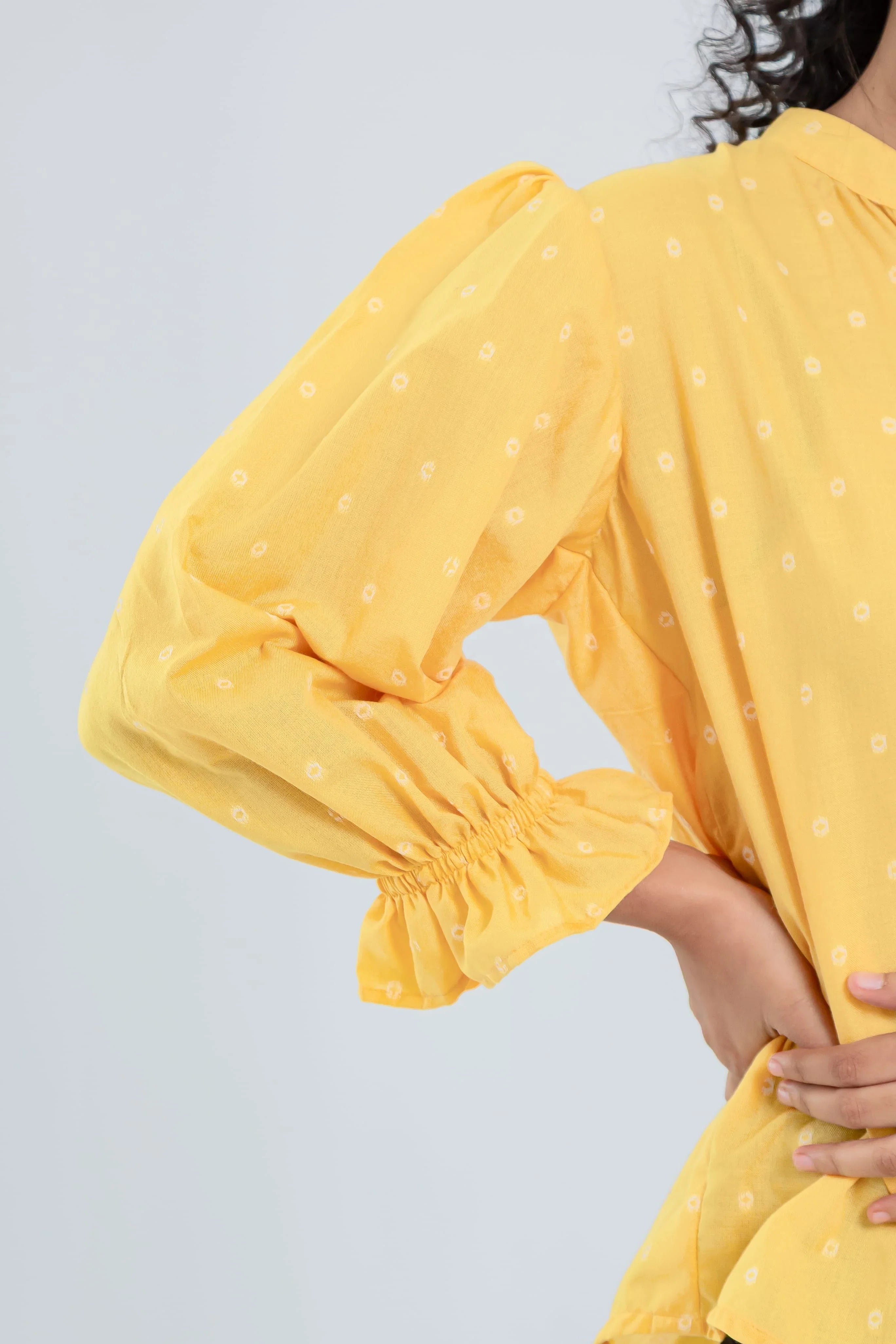 Yellow long sleeve dress with small white polka dots and gathered cuffs