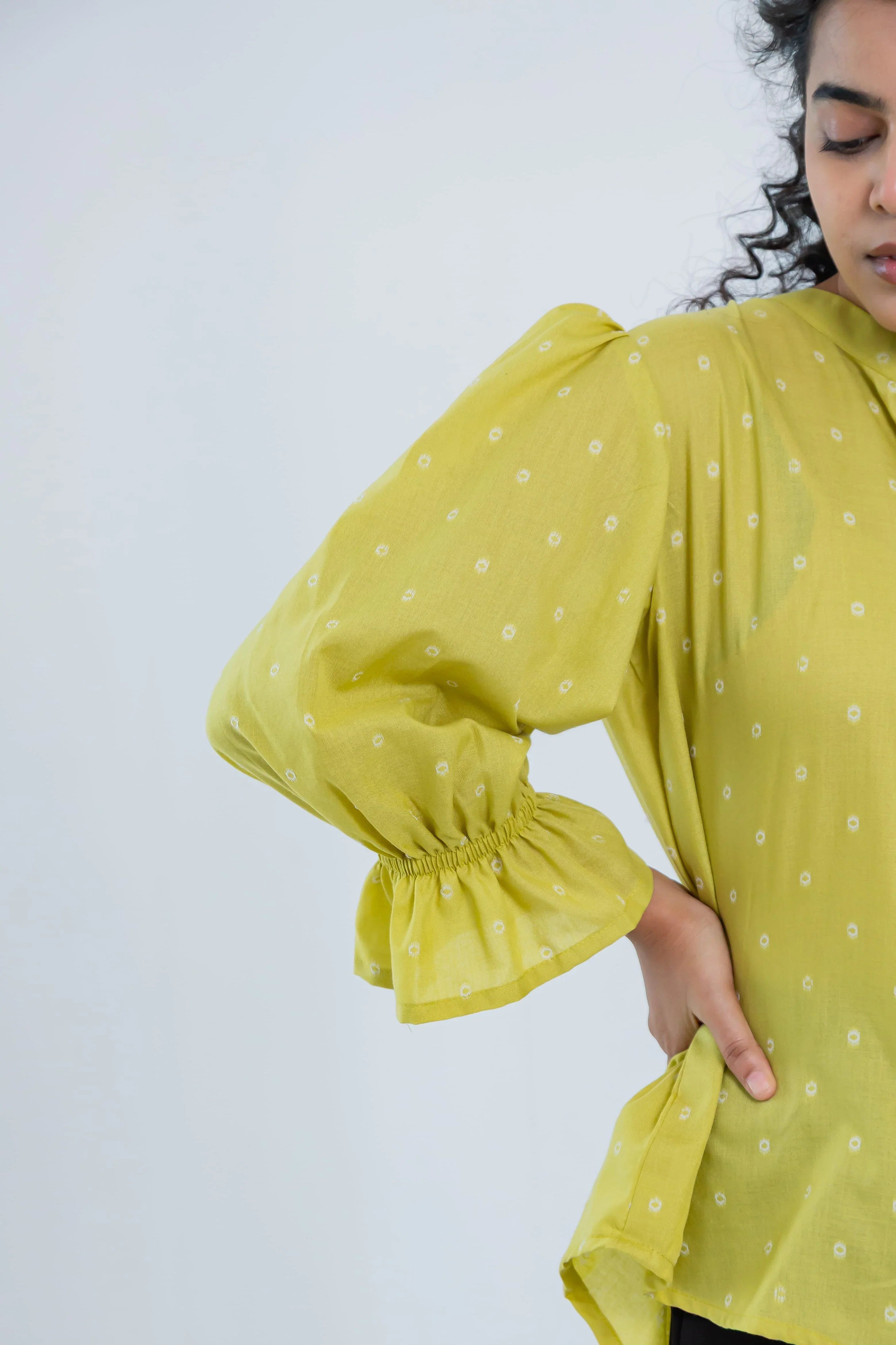 Yellow puff sleeve women’s top with small white polka dot print and ruffle cuff