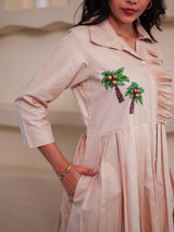 Beige women's dress with palm tree embroidery, button-down front, and three-quarter sleeves