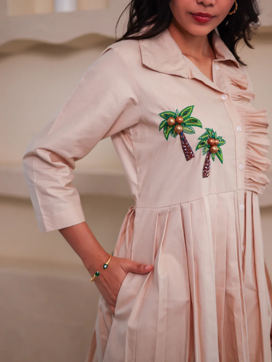 Beige women's dress with palm tree embroidery, button-down front, and three-quarter sleeves