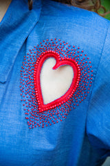 Blue women's dress with red heart-shaped beaded cutout detail on chest