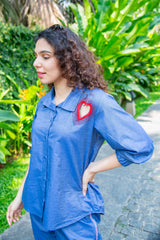 Woman in blue co-ord set with heart cut-out detail, posing outdoors, trendy casual style