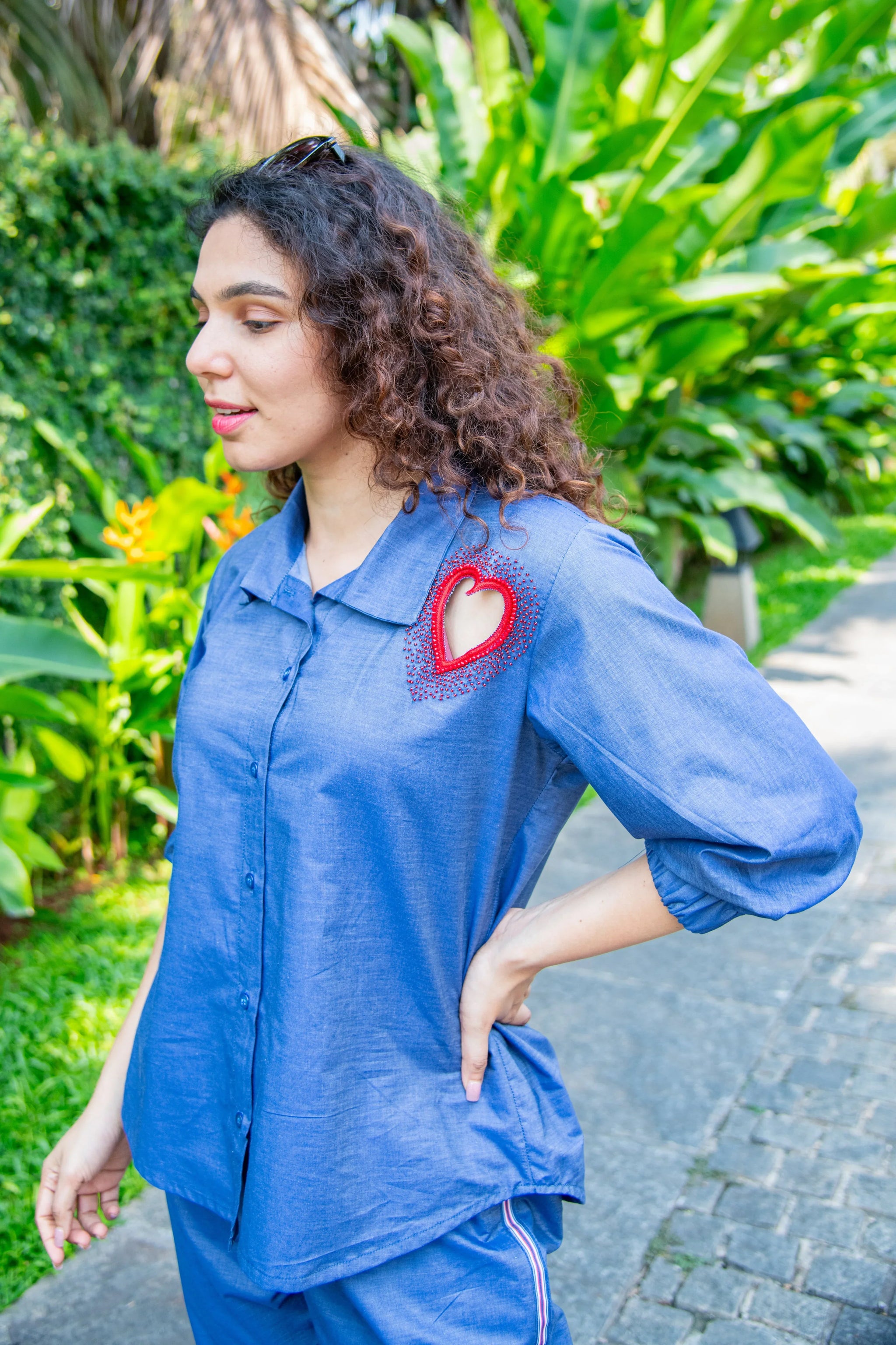 Woman in blue co-ord set with heart cut-out detail, posing outdoors, trendy casual style