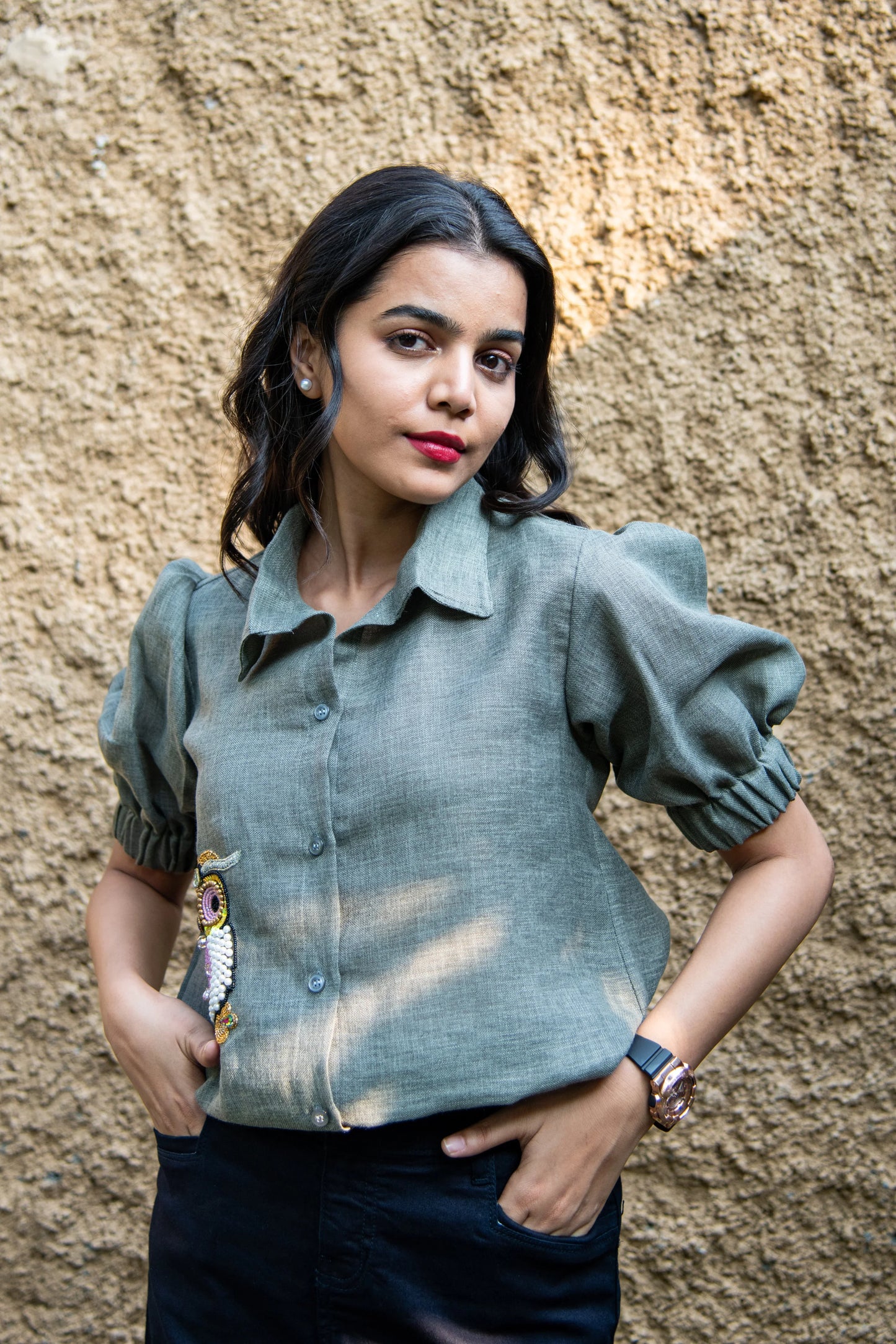 Woman in puff sleeve green linen shirt with bead embroidery, standing outdoors