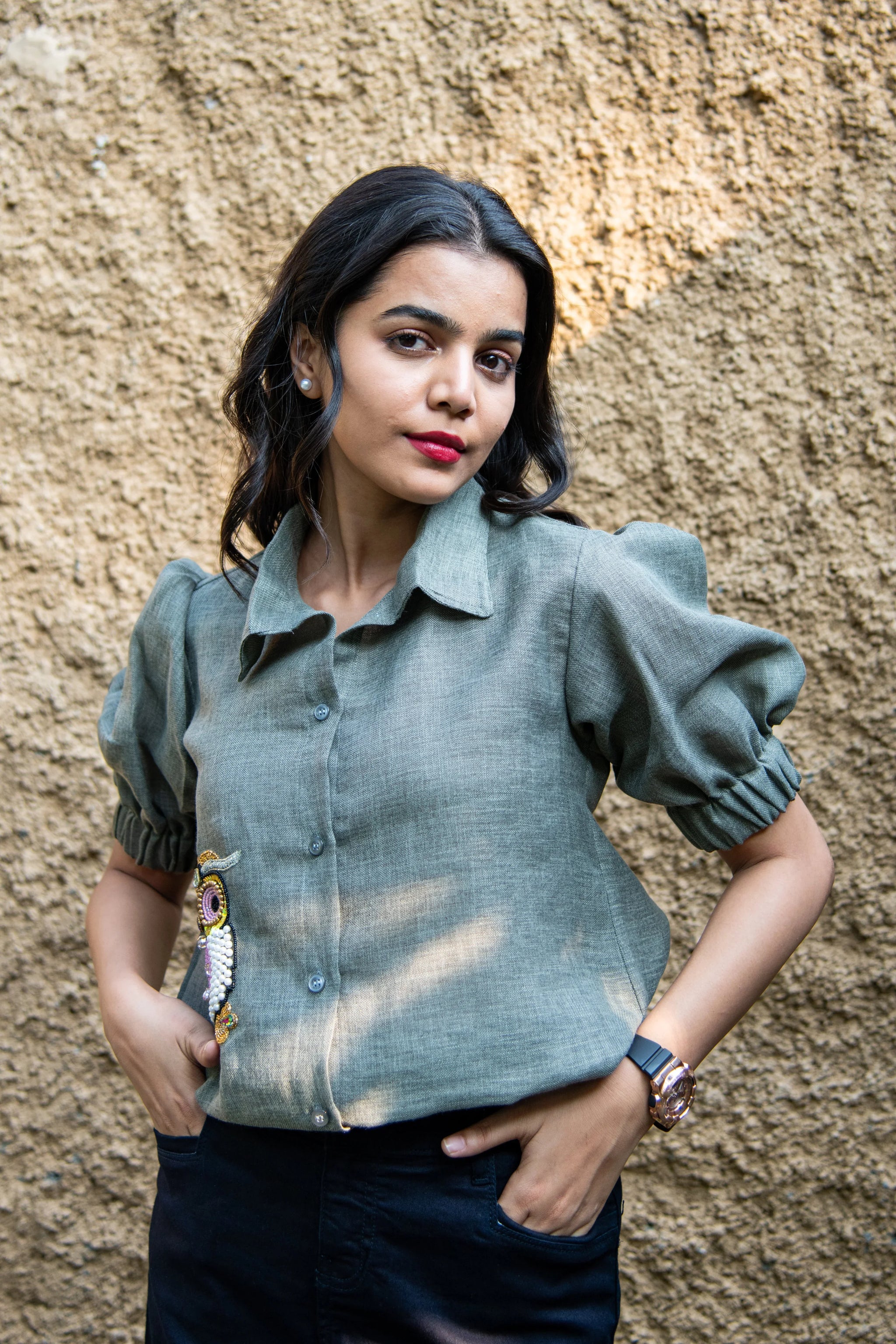 Woman in puff sleeve green linen shirt with bead embroidery, standing outdoors