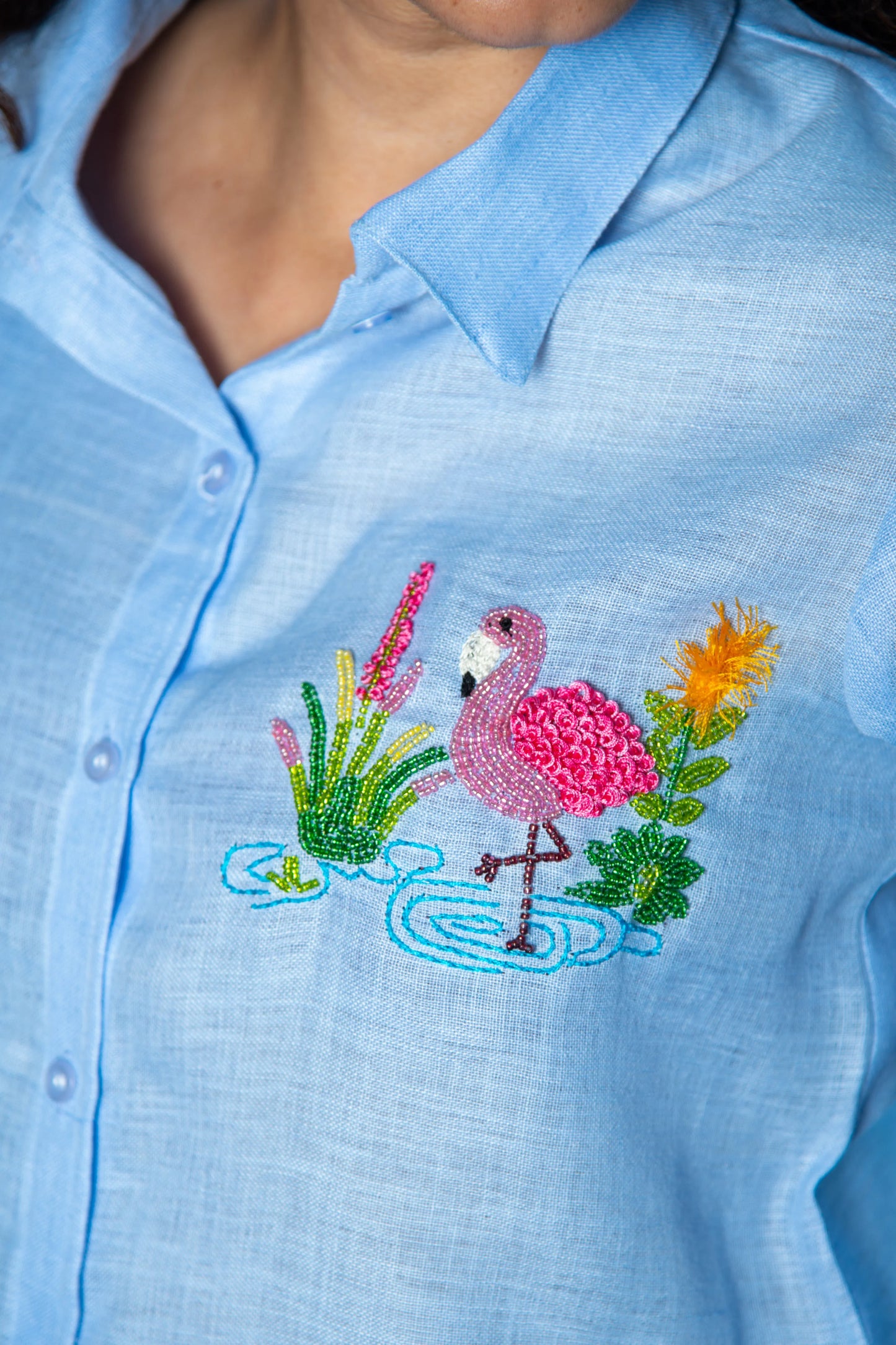 Light blue women’s shirt with pink flamingo and floral embroidery detail
