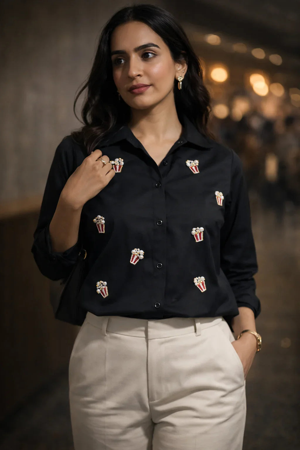 Black shirt with popcorn embroidery paired with beige trousers for stylish everyday wear