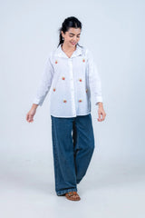 White shirt with popcorn embroidery paired with wide-leg jeans for casual everyday style