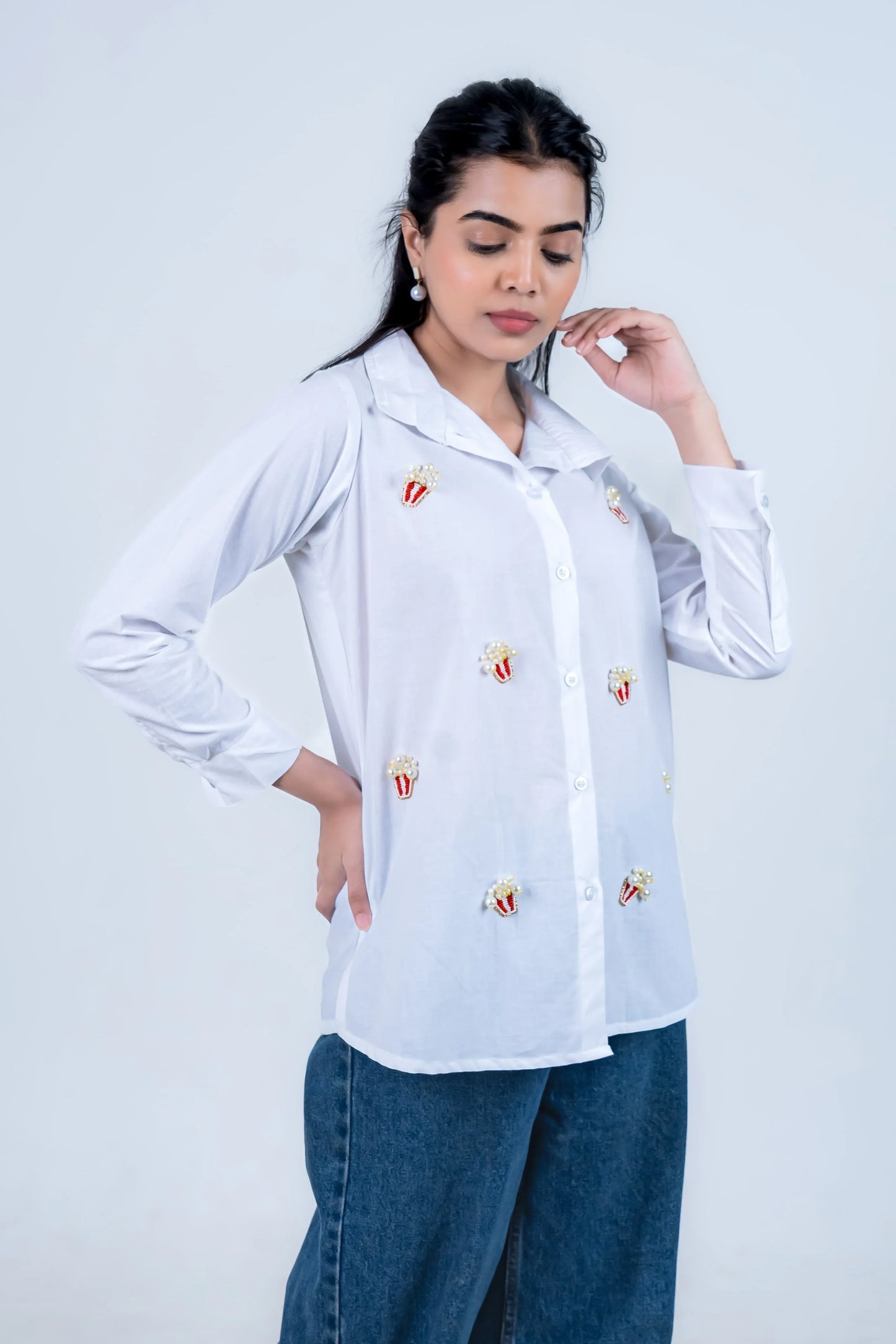 White shirt with popcorn embroidery, paired with wide-leg jeans for casual style