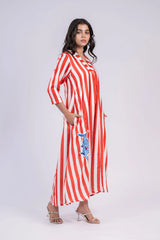 Woman wearing a red and white striped maxi dress with embroidered blue fish, three-quarter sleeves
