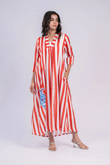 Woman wearing a red and white striped maxi dress with a blue fish motif, three-quarter sleeves