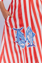 Red and white striped women's dress with blue fish embroidery and side pocket.