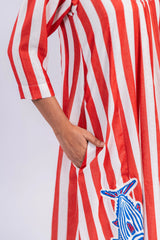 Red and white striped women’s dress with blue embroidered fish detail and pocket