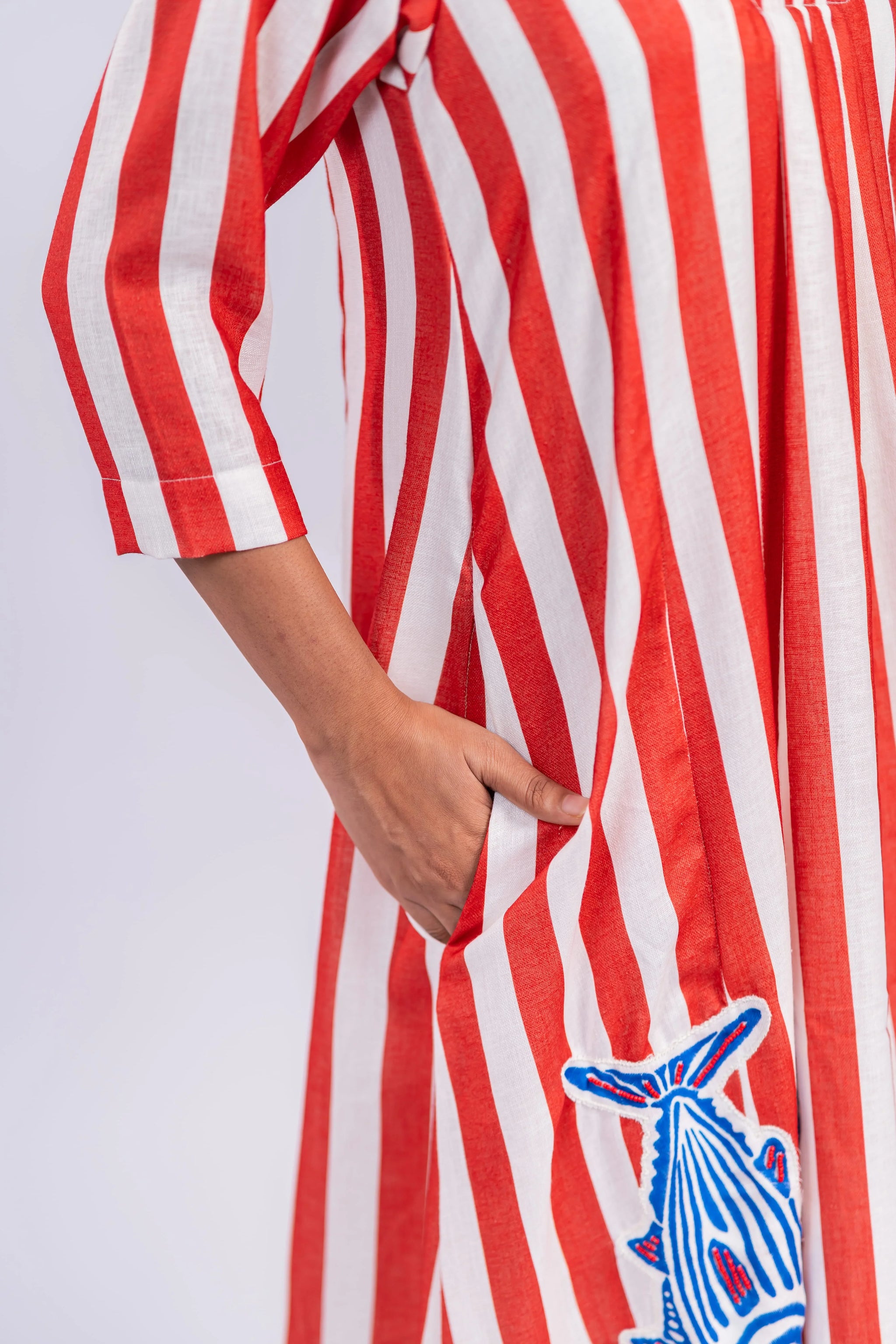 Red and white striped women’s dress with blue embroidered fish detail and pocket