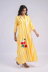 Woman wearing yellow and white striped maxi dress with cherry print, three-quarter sleeves