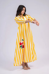 Woman in yellow and white striped maxi dress with cherry embroidery, casual summer fashion