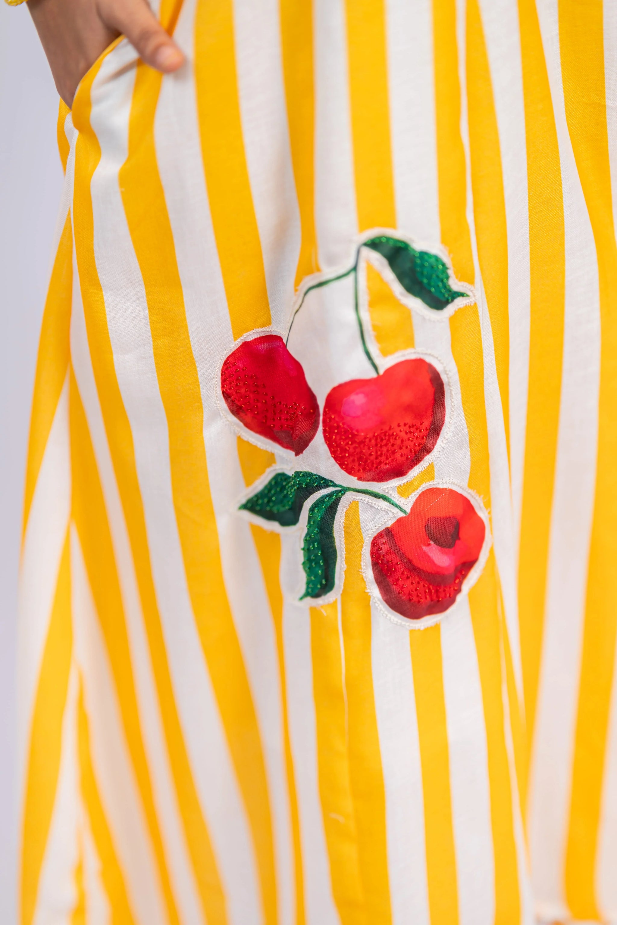 Yellow and white striped dress with red cherry embroidery detail