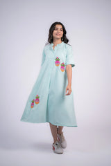 Mint green striped dress with pineapple embroidery, short sleeves, button front, and flared skirt, paired with sneakers.