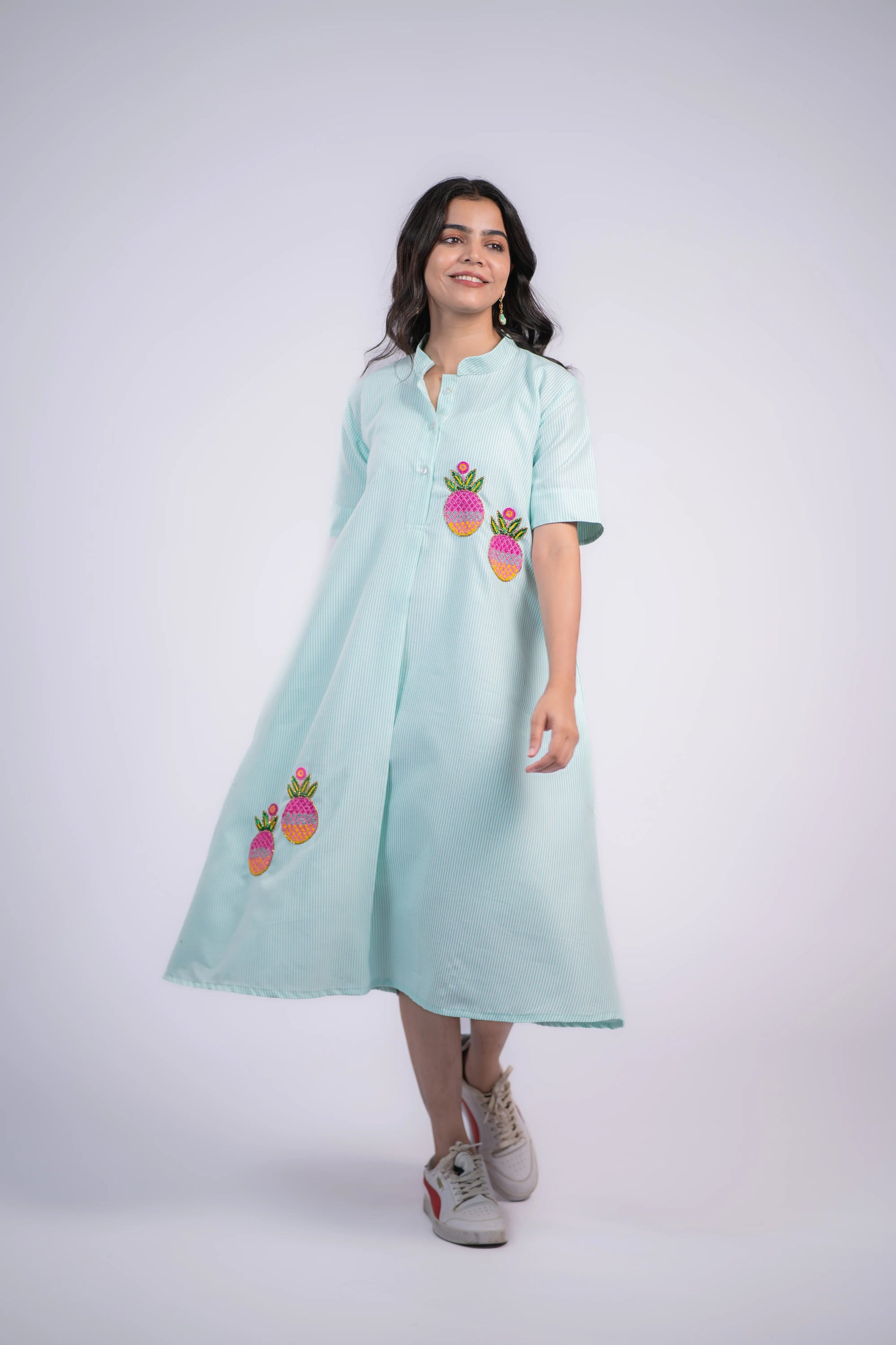 Mint green striped dress with pineapple embroidery, short sleeves, button front, and flared skirt, paired with sneakers.