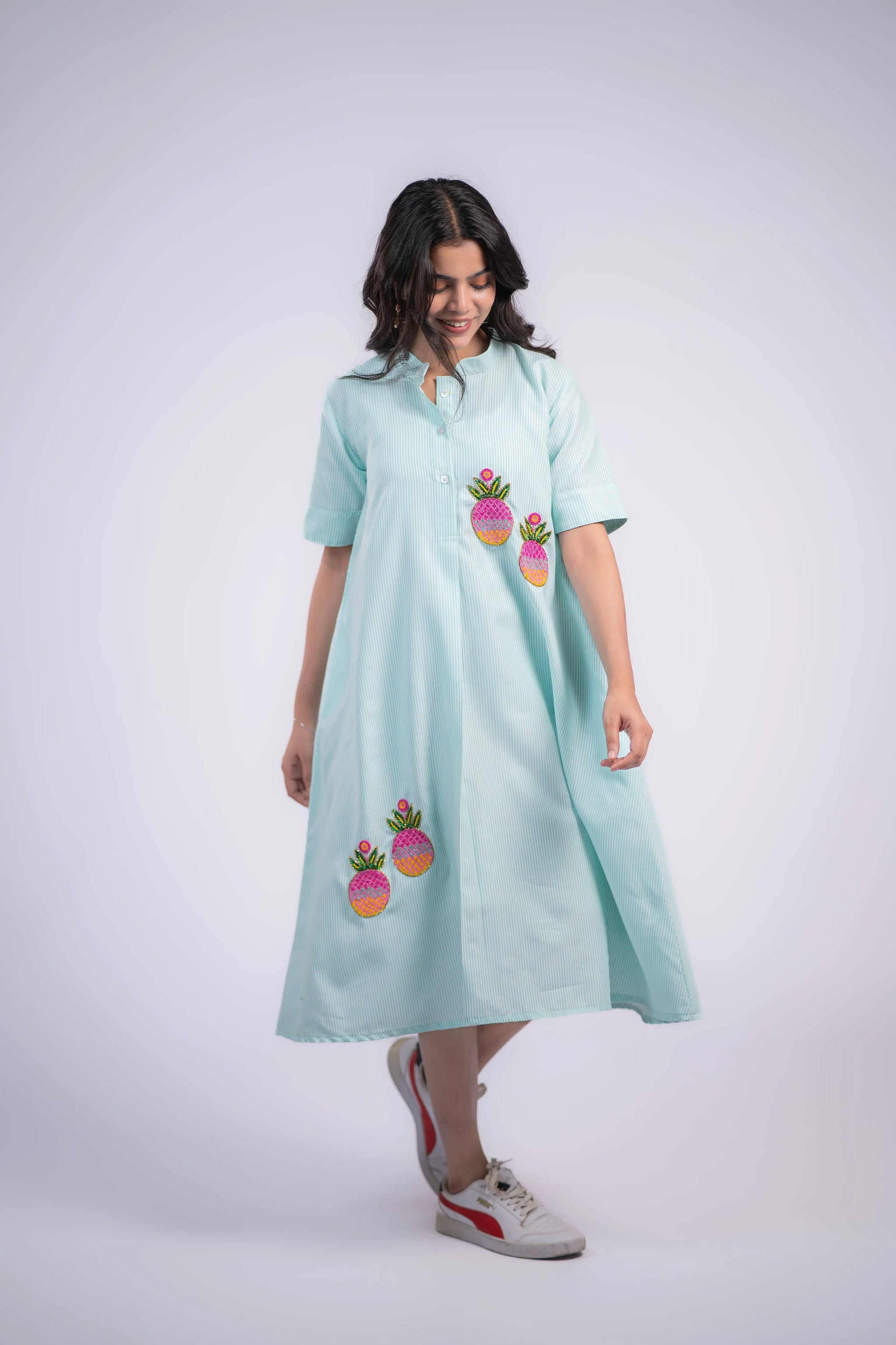 Light blue striped dress with colorful pineapple embroidery, paired with white sneakers