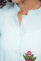 Light blue striped shirt with colorful floral embroidery and button details
