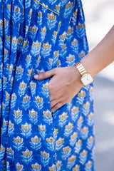 Blue floral print dress with yellow accents, paired with gold watch for everyday women's fashion