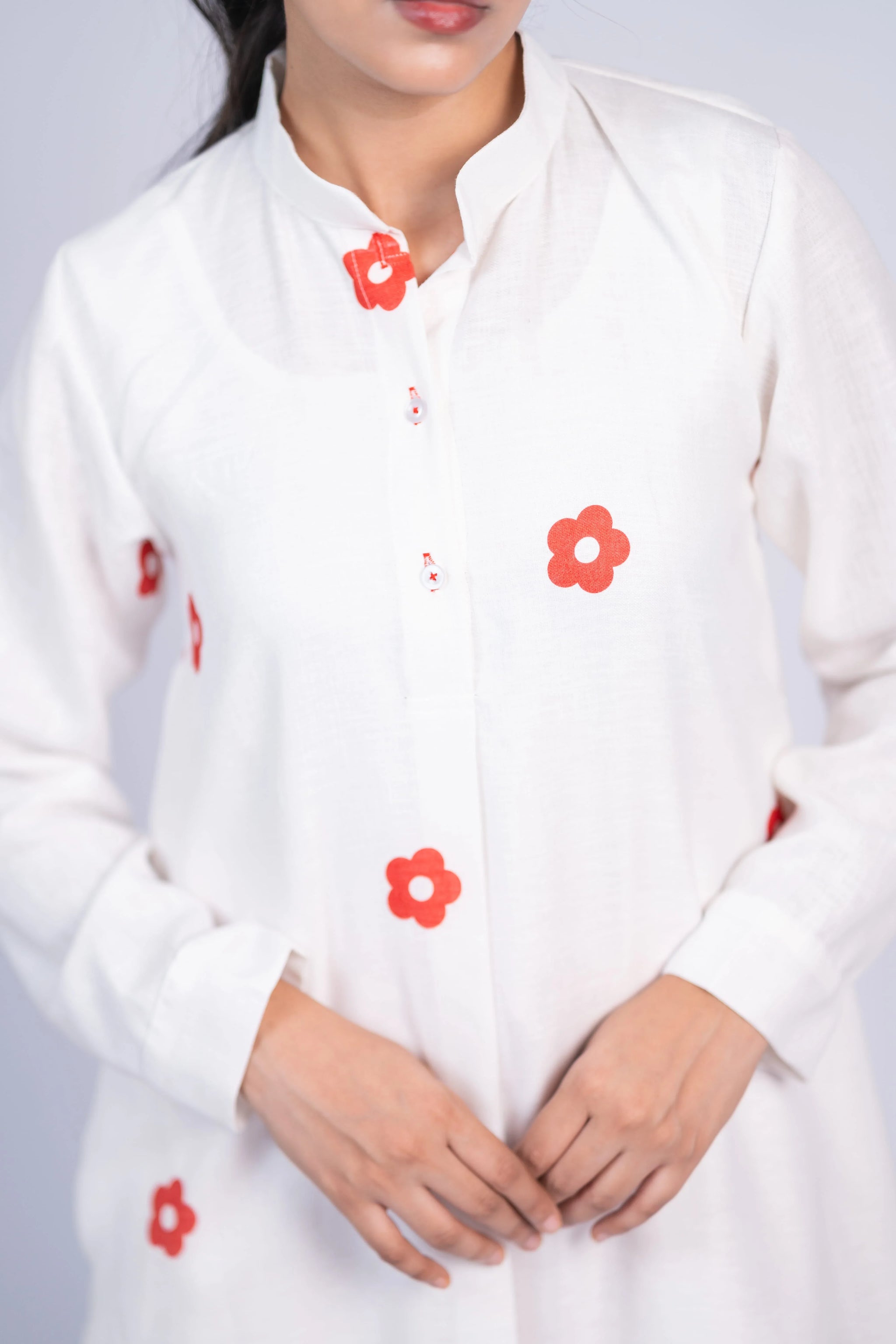 White long-sleeve kurta with red floral prints, button-up front, worn by a woman