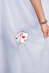 Close-up of a blue and white striped dress with embroidered playing cards detail