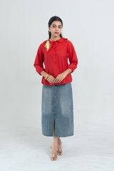 Red button-up blouse with parrot embroidery, paired with denim midi skirt and clear heels for women's fashion.