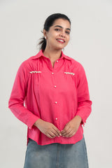 Pink pearl-buttoned shirt with embellished chest details, paired with denim skirt for everyday wear