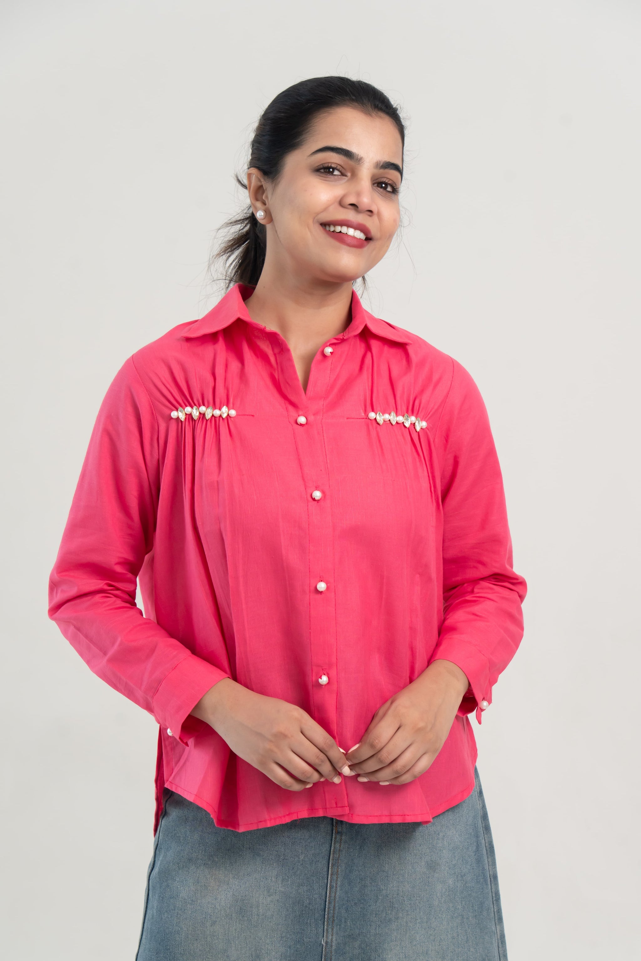 Pink pearl-buttoned shirt with embellished chest details, paired with denim skirt for everyday wear