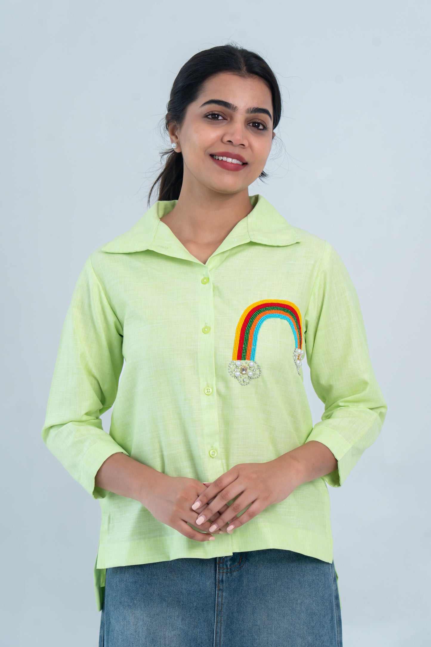 Lime green button-down shirt with beaded rainbow embroidery, paired with denim skirt for everyday wear.