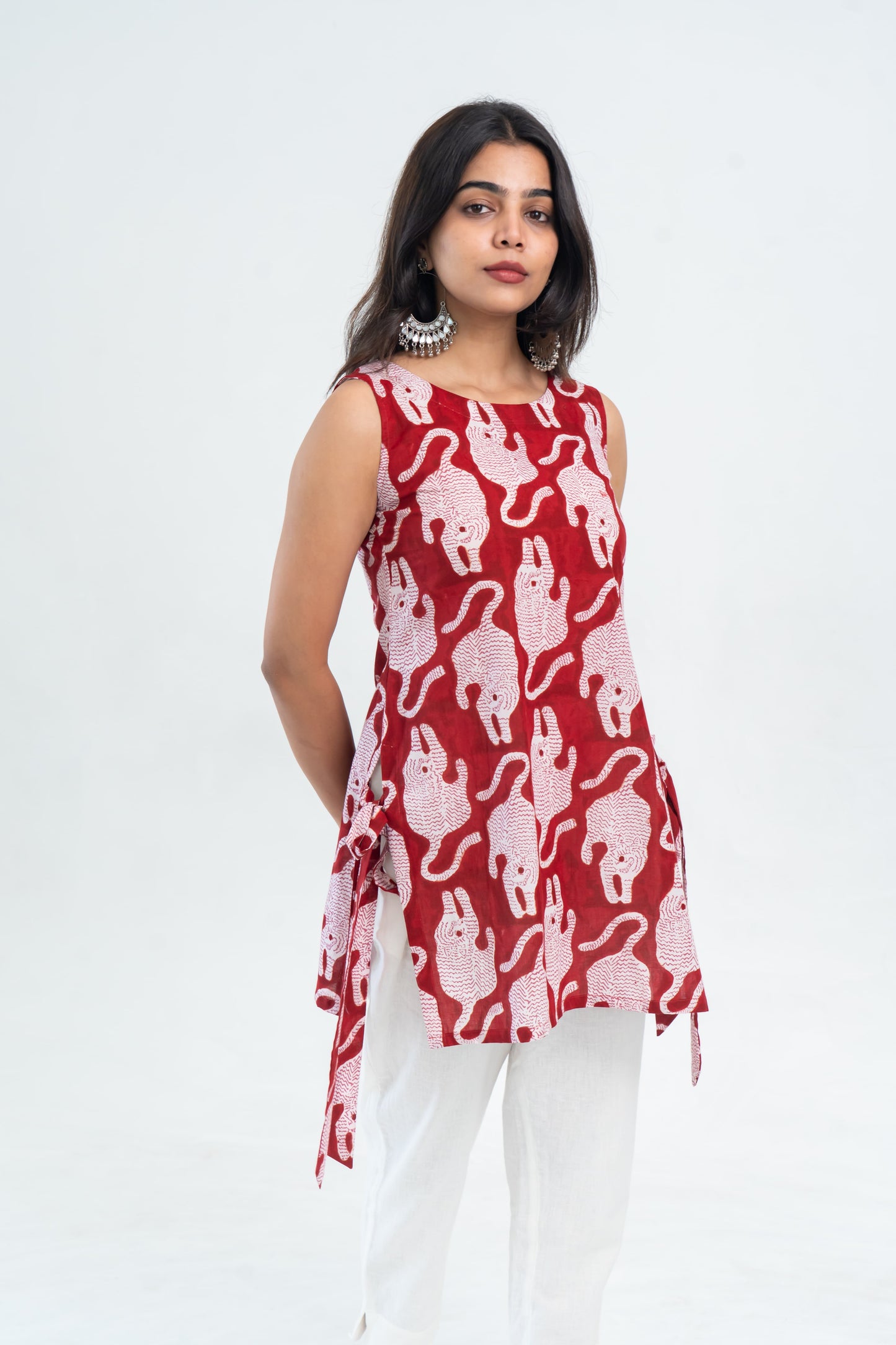 Red sleeveless top with white elephant print, side ties, paired with white pants for casual women's wear