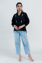 Black embroidered shirt with light blue jeans and clear heels