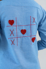 Blue gingham shirt with red heart and X embroidery in tic-tac-toe design