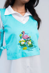 Turquoise vest with beaded flamingo and floral embroidery over white shirt