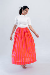 Woman wearing vibrant orange and pink striped maxi skirt with white top, perfect for trendy everyday styles.