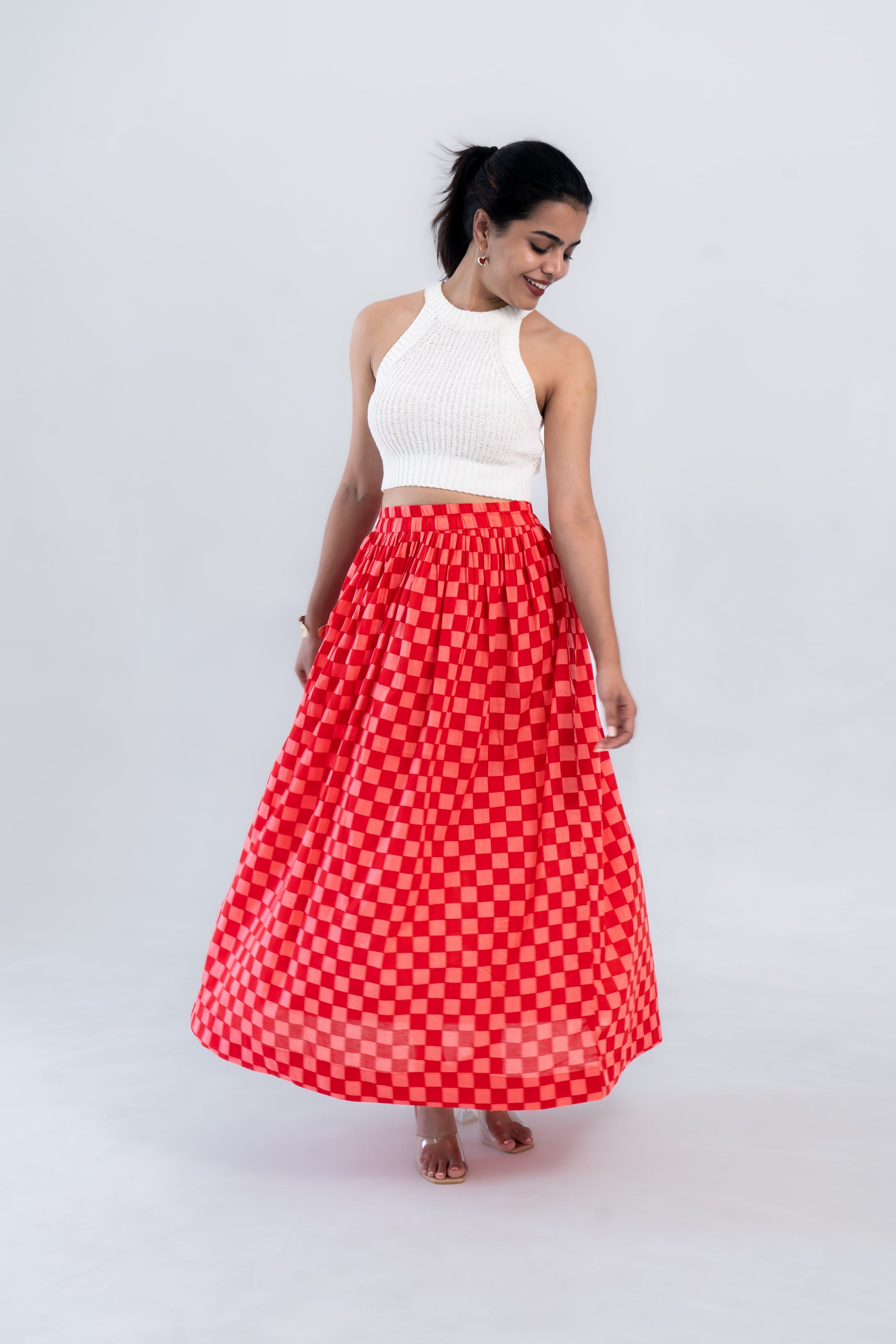 Red checkered maxi skirt with white knit crop top, stylish women's fashion