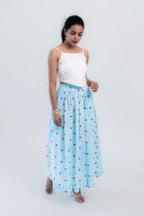 Woman in white crop top and blue striped skirt with pink hearts, stylish everyday outfit