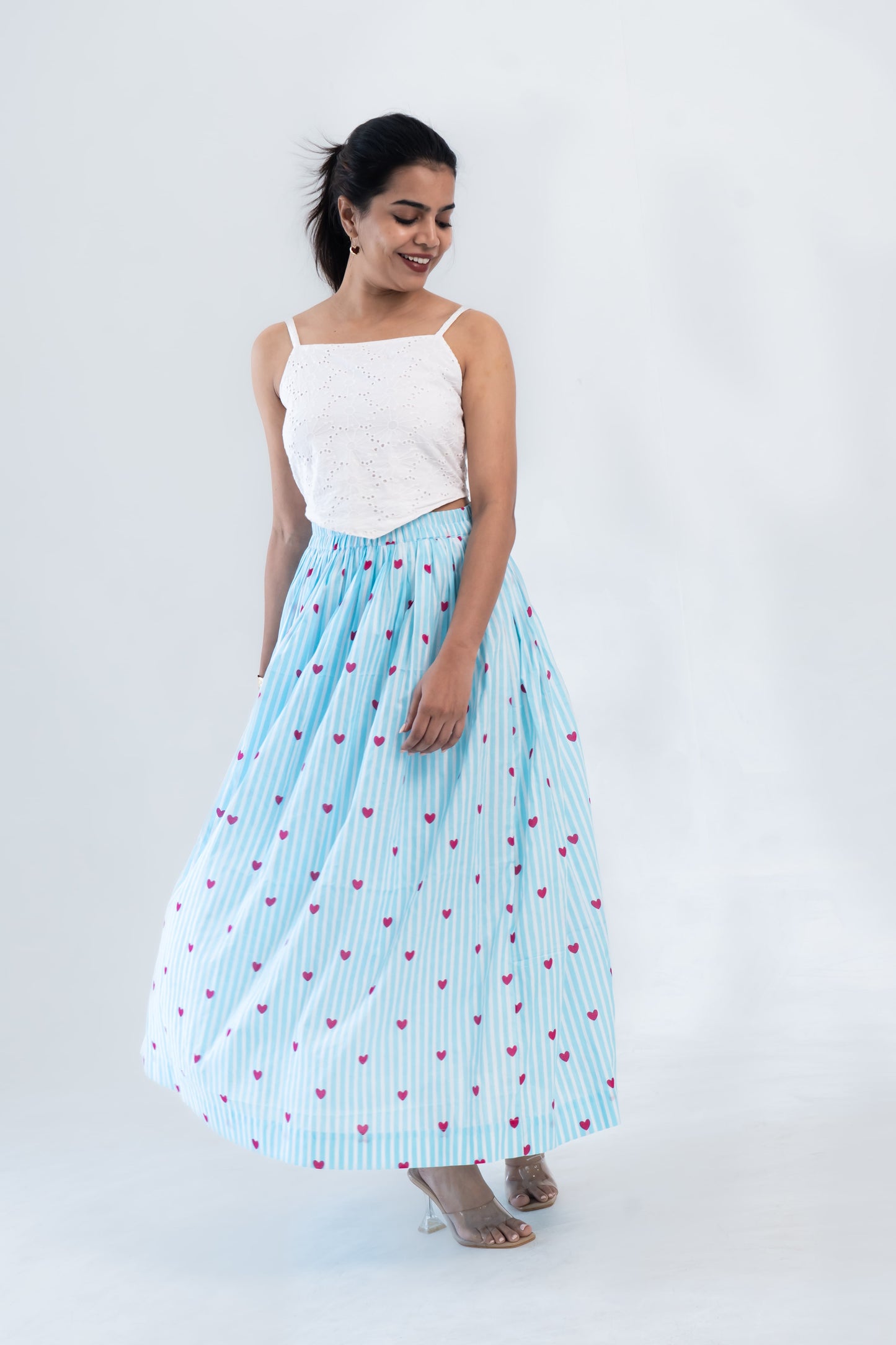 Woman in white eyelet crop top and blue striped heart-print maxi skirt, stylish co-ord set