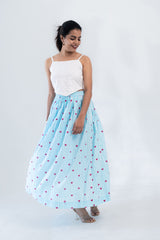 Woman in white eyelet crop top and blue striped heart-print maxi skirt, stylish co-ord set