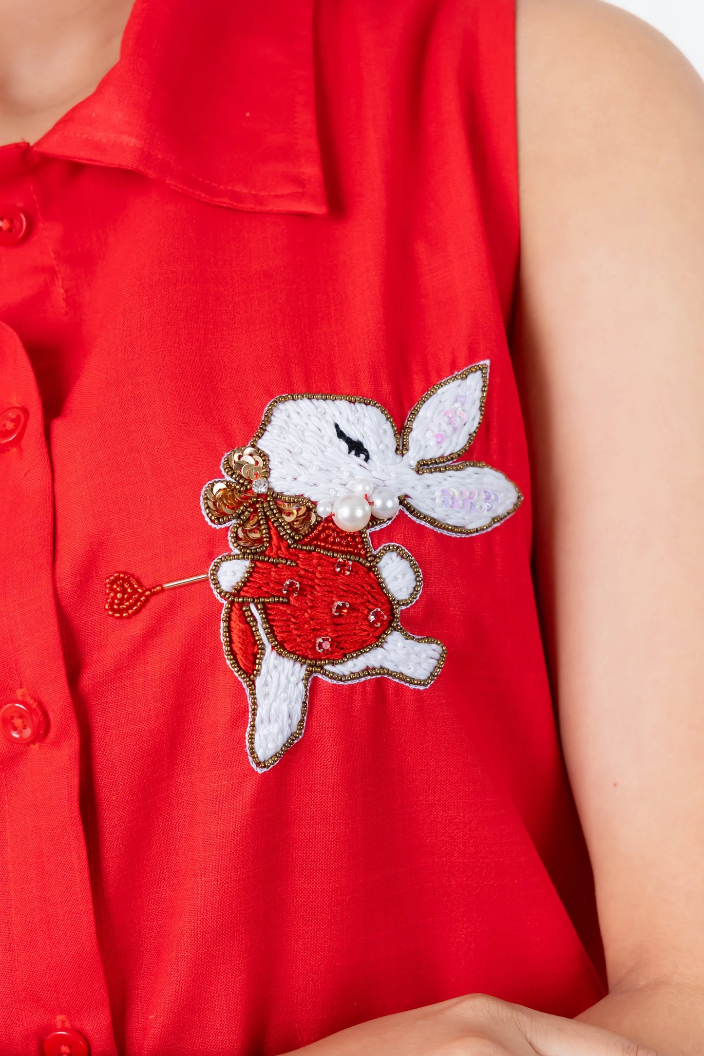 Red women's dress with embroidered bunny appliqué, beads, and pearls, featuring a playful design and button front.