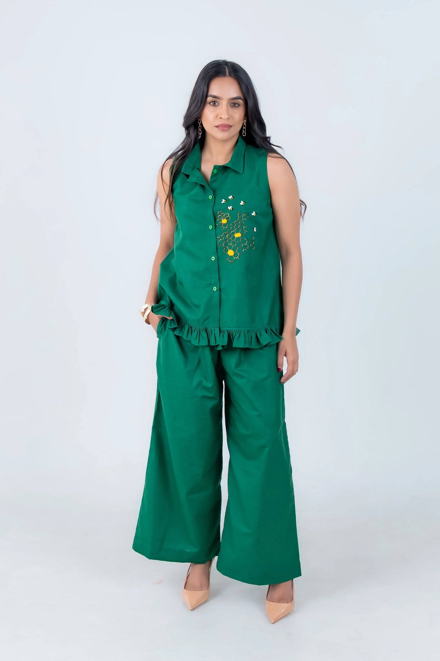 Emerald green sleeveless co-ord set with floral embroidery and ruffle hem, paired with wide-leg pants