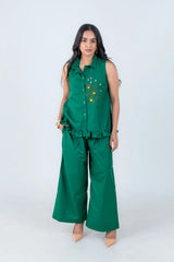 Emerald green sleeveless co-ord set with floral embroidery and ruffle hem, paired with wide-leg pants