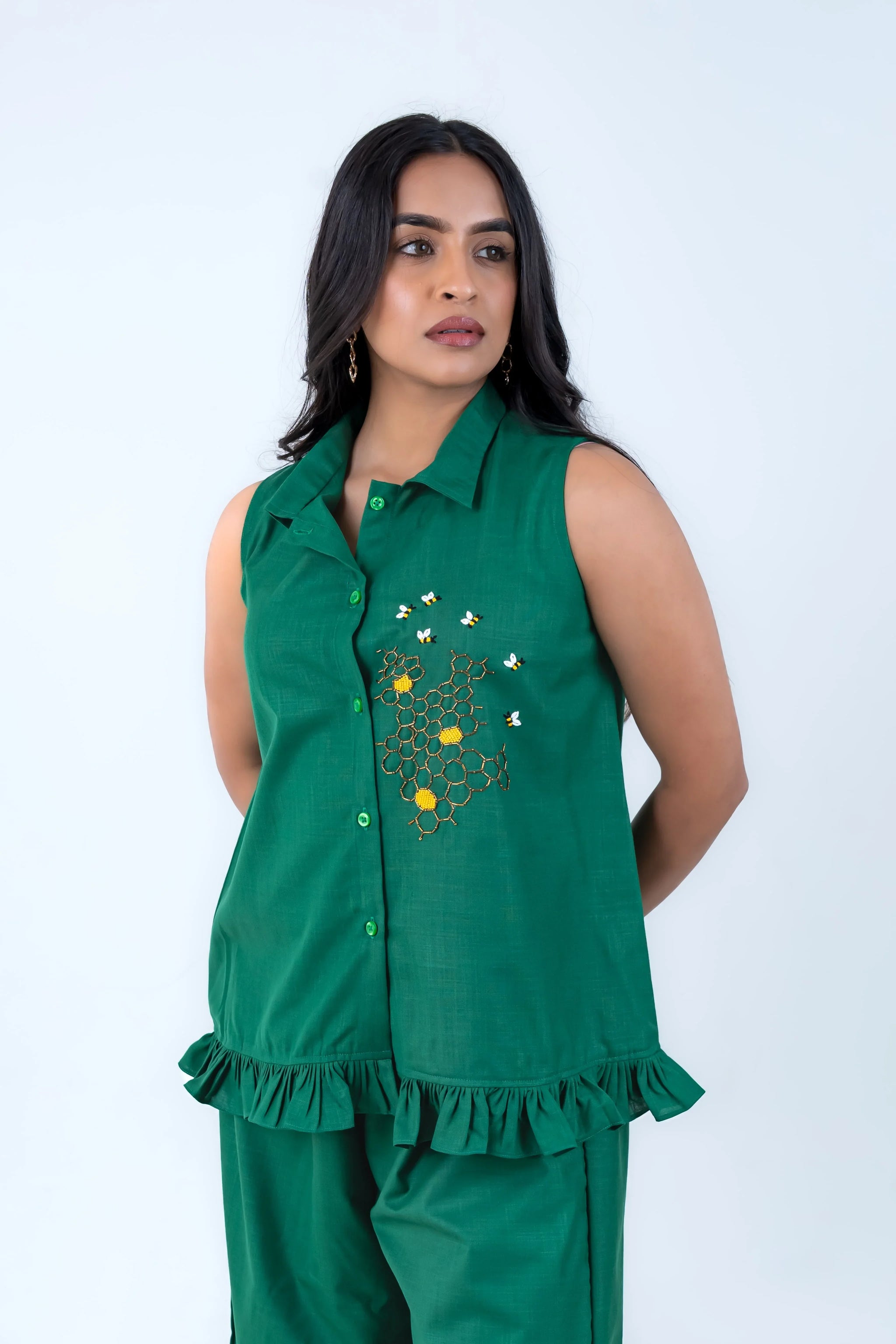 Green sleeveless shirt with bee and honeycomb embroidery, ruffled hem, paired with matching pants