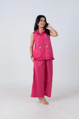 Pink sleeveless bird-embroidered shirt with ruffle hem paired with matching wide-leg pants, stylish women's co-ord set