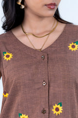 Brown button-up dress with embroidered sunflowers, gold necklaces, and statement earrings for women's fashion