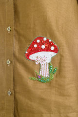 Beaded mushroom embroidery on mustard shirt with floral details and pearl accents