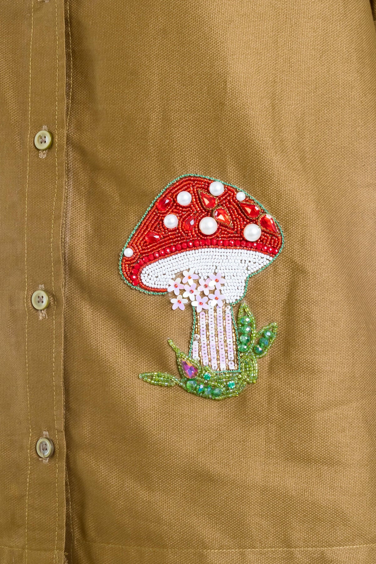 Beaded mushroom embroidery on mustard shirt with floral details and pearl accents