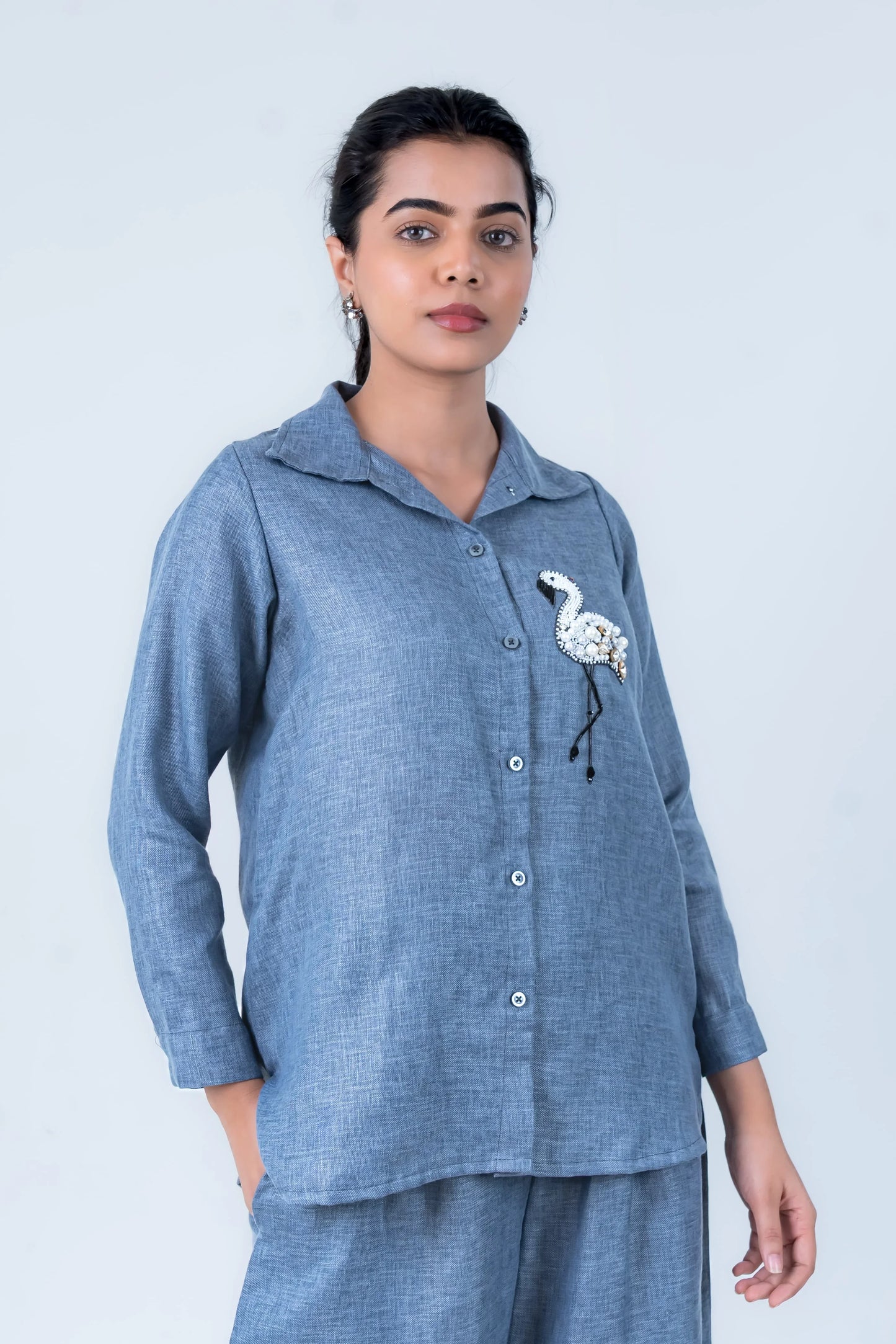 Blue linen shirt with flamingo embroidery, paired with matching pants for casual comfort.